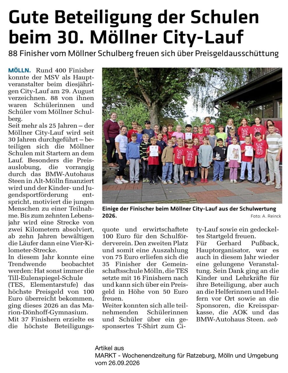 Zeitungsartikel mit Bild einer Gruppe von Schülern und Lehrern steht vor einem Gebäude und hält eine Urkunde bei einer Preisverleihung zum Möllner City-Lauf 2026