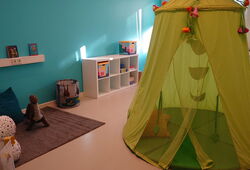 Spielzimmer mit blauer Wand und grünem Zelt
